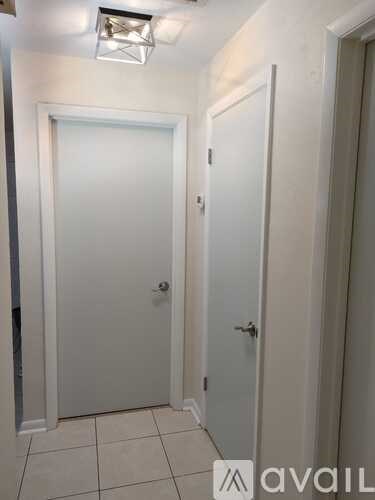 A hallway with two doors and a tiled floor.