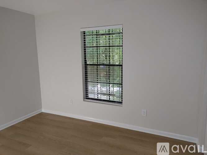 A room with a window covered by a grid of blinds.