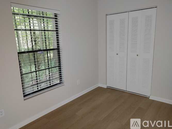 A room with a window and a white wardrobe.