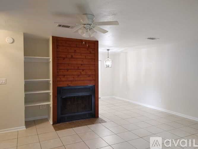 A room with a fireplace and a ceiling fan.
