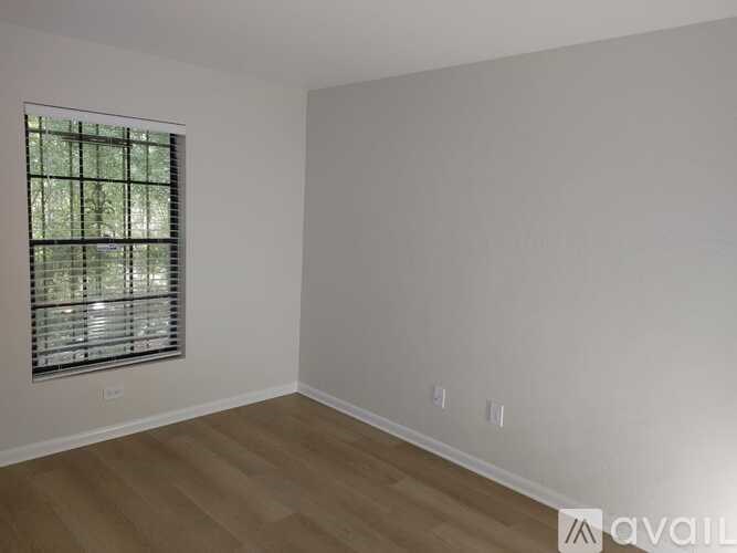 A room with a window and wooden flooring is available.