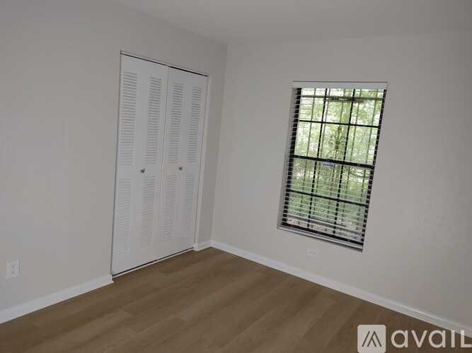 A room with a white door and a window with blinds.