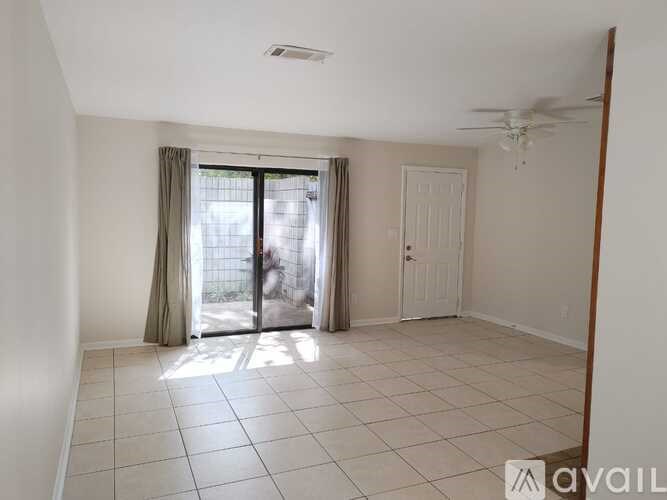 A room with a sliding glass door and a ceiling fan.