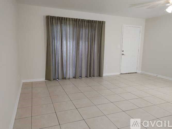 A room with a white door and a grey curtain.