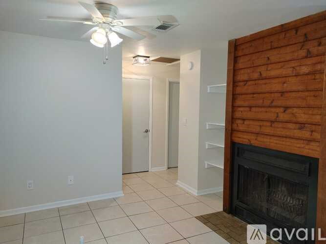 A room with a fireplace and a ceiling fan.