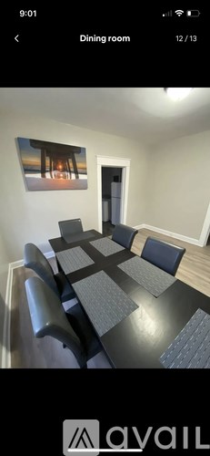 A dining room with a large table and chairs.