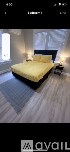 A bedroom with a yellow bed and a grey rug.
