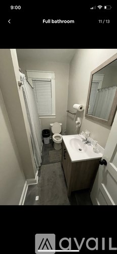 A bathroom with a toilet, sink, and mirror.