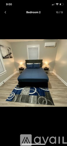 A bedroom with a bed, two lamps, and a window.