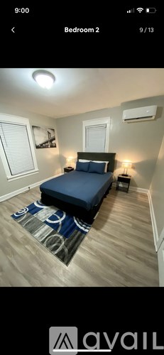 A bedroom with a bed, nightstand, and window.