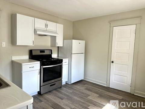 A kitchen with white appliances and cabinets is available for rent.
