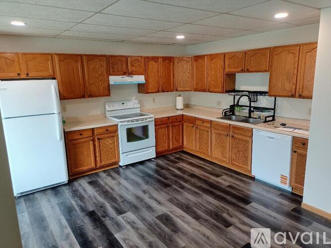 A kitchen with wooden cabinets and a white fridge.