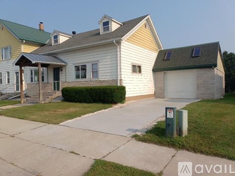 A two-story house with a garage and a driveway.