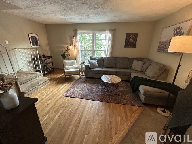 A living room with a grey couch and a wooden floor.