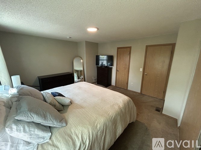 A bedroom with a bed, dresser, and mirror.