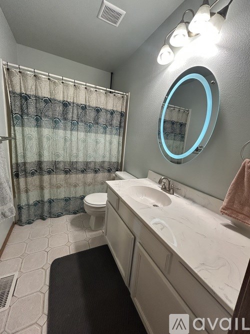 A bathroom with a toilet, sink, and shower curtain.