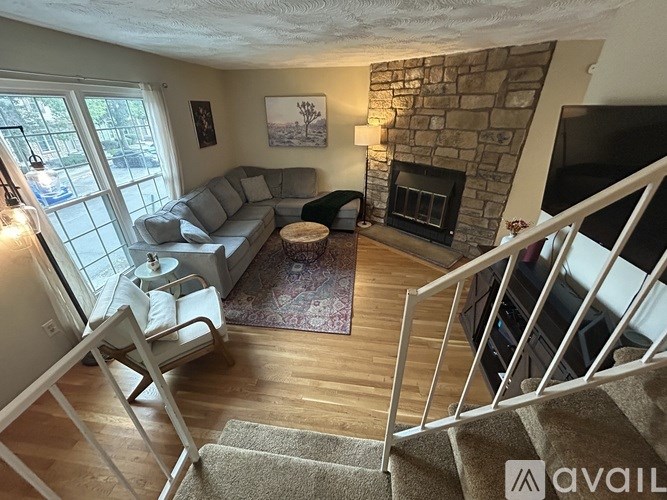 A living room with a couch, chair, and fireplace.