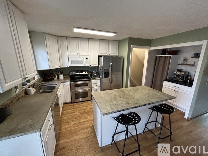 A kitchen with a marble countertop and white cabinets.