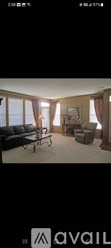 A living room with a black couch and a coffee table.