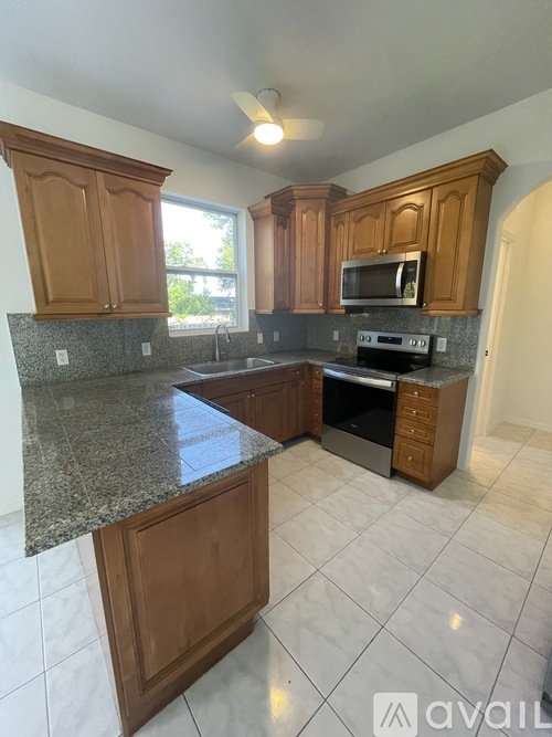 A kitchen with wooden cabinets and granite countertops.