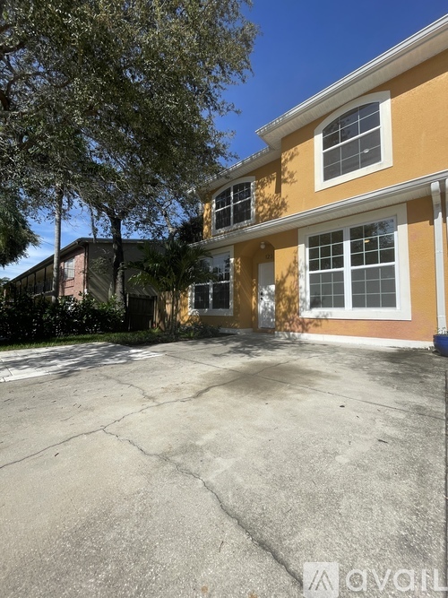A yellow house with a tree in front.
