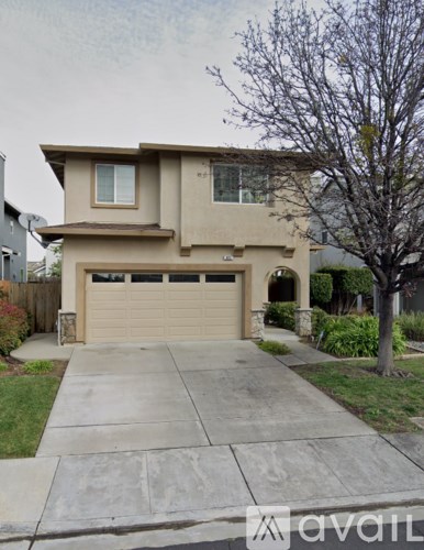 A two-story house with a garage and a driveway.