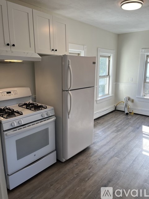 A kitchen with a white stove and refrigerator.
