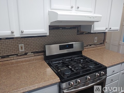 A modern kitchen with a black stove top oven.