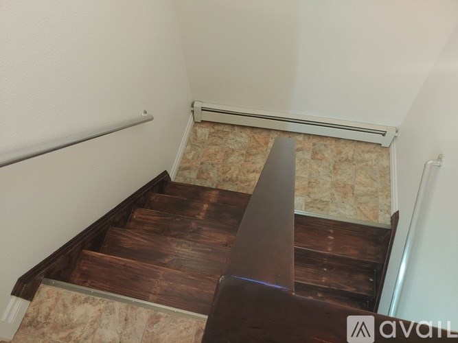 A staircase with wooden steps and a metal handrail.