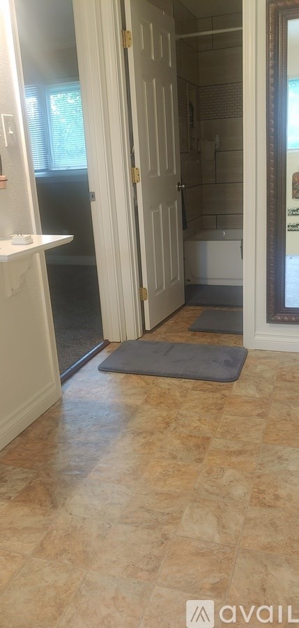 A bathroom with a tiled floor and a white door.