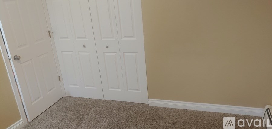 A room with a tan wall and a white door.