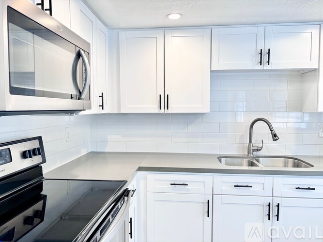 A modern kitchen with white cabinets and a stainless steel oven.