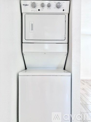 A white Whirlpool dishwasher and dryer stacked on top of each other.