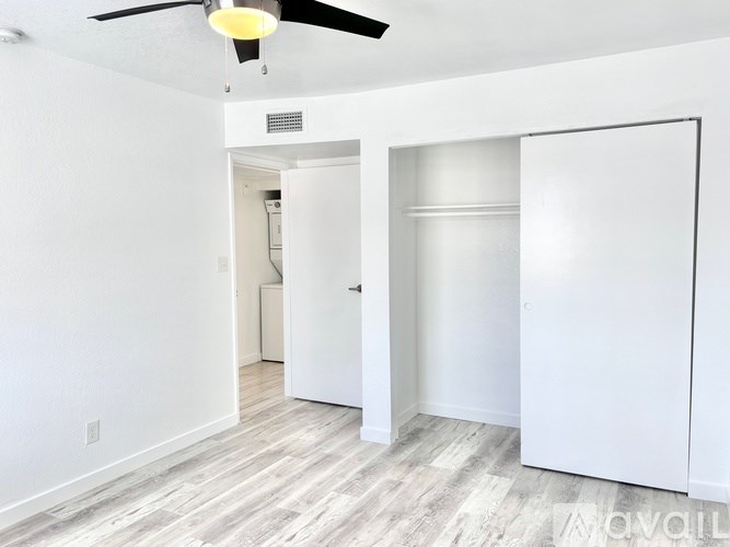 A room with a ceiling fan and a door leading to another room.