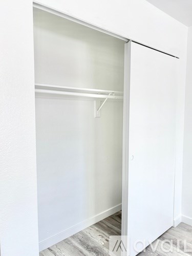 A white closet with a shelf and a hanger.