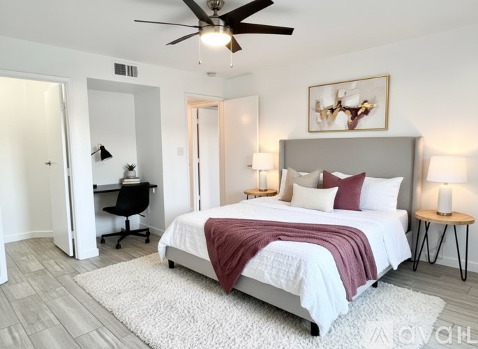 A bedroom with a bed, desk, and chair.