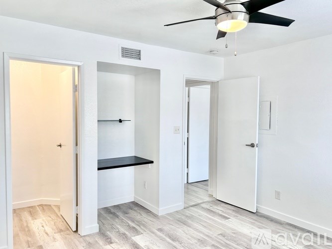 A room with a ceiling fan and a bench.
