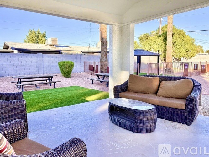 A patio with a sofa, chairs, and a table.