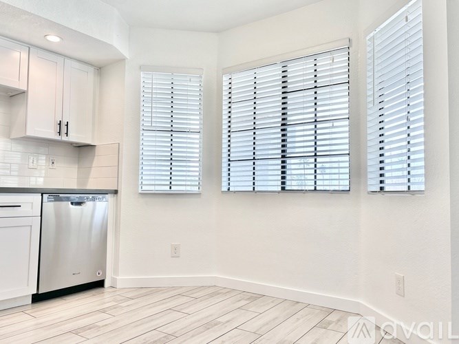 A kitchen with white cabinets and a stainless steel dishwasher.