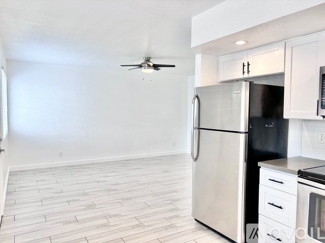 A kitchen with a stainless steel refrigerator and a fan on the ceiling.