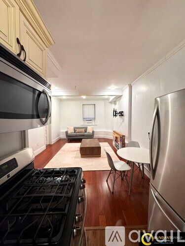 A kitchen with white cabinets and a stainless steel stove.