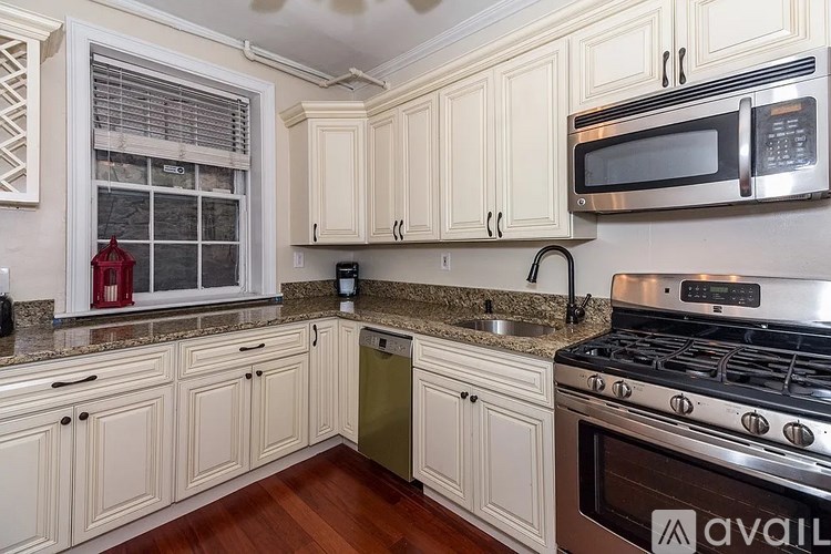 A kitchen with white cabinets and a stainless steel stove.