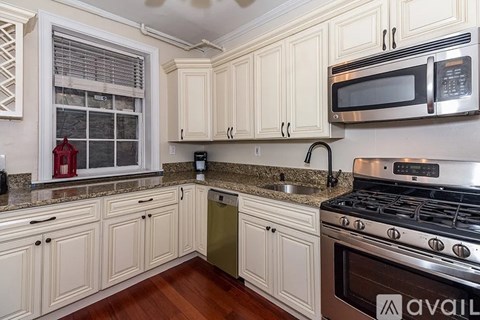 A kitchen with white cabinets and a stainless steel stove.