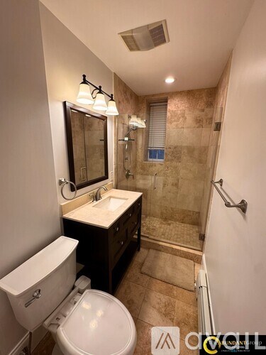 A bathroom with a toilet, sink, and shower.
