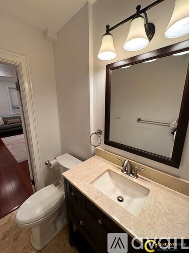 A bathroom with a toilet, sink and mirror.