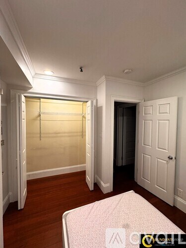 A white bedroom with a bed and a closet.