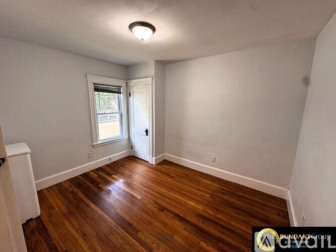 A room with wood flooring and a window.