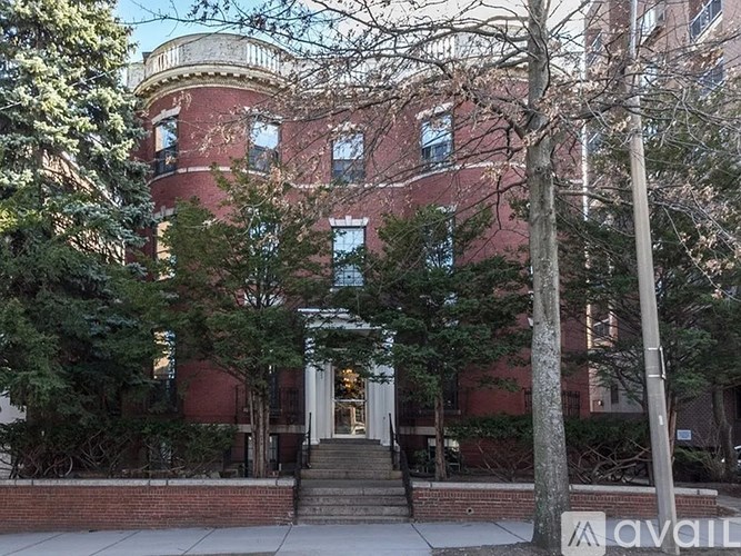 A red brick building with a white door and steps leading up to it.