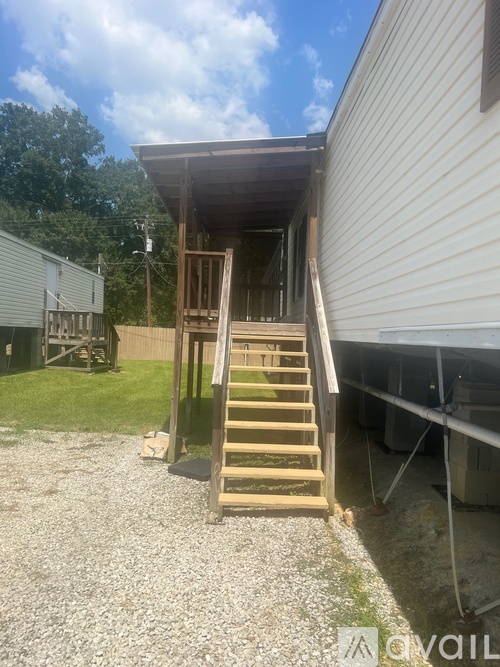 A wooden staircase leads up to a covered porch area.