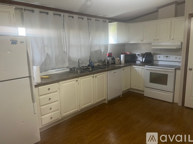 A kitchen with white cabinets and appliances.